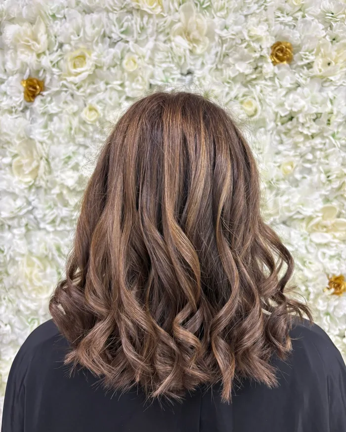 Balayage brun caramel et boucles réalisés à Nouvel'Hair, salon de coiffure à Saint-Pol-sur-Mer